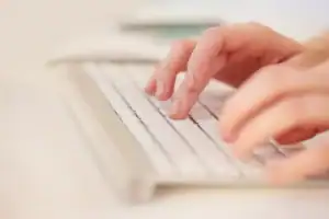 Close-up of hands typing on a keyboard for HR solutions.