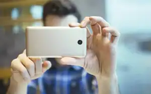 Businesswoman taking a photo with smartphone at work, focusing on capturing a moment in a profession.