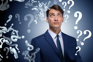 Businessman in uncertainty concept with many unanswered questions