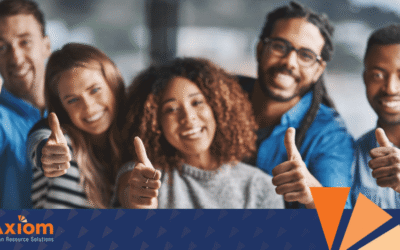 Diverse group of smiling employees giving thumbs up, representing teamwork and trust in the workplace, with Axiom Human Resource Solutions branding visible.