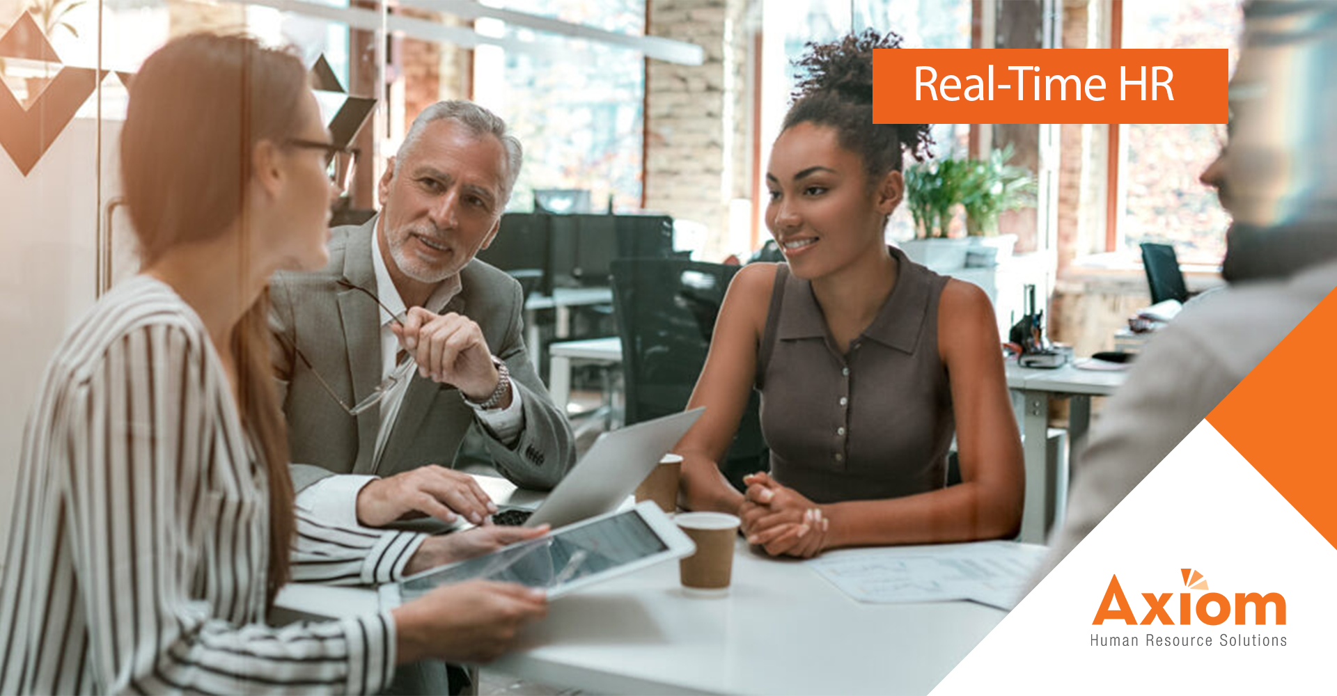 Business meeting discussing HR practices, featuring diverse professionals engaging in conversation with documents and a tablet, Axiom Human Resource Solutions branding.
