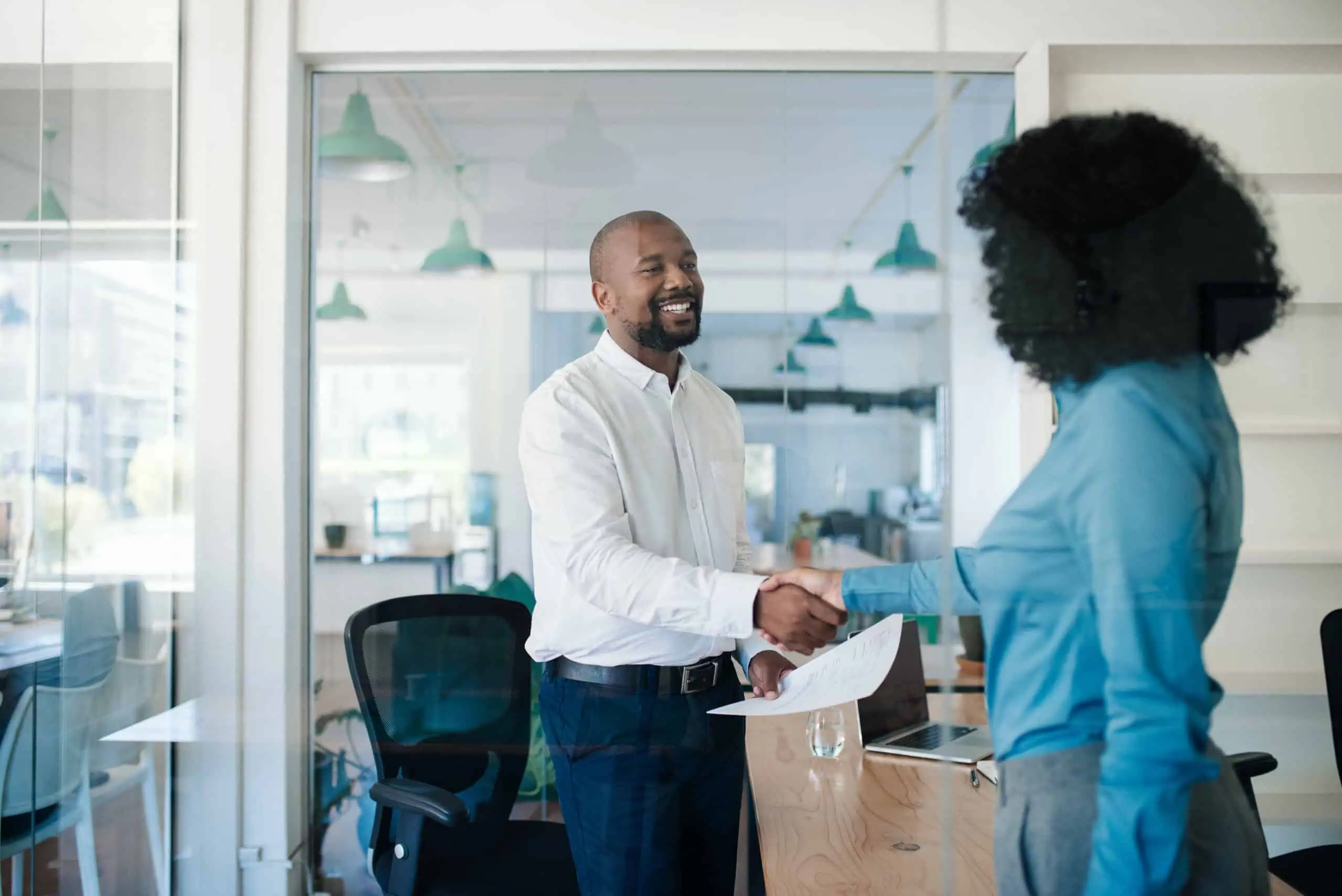 Smiling HR manager meeting with a new hire employee.