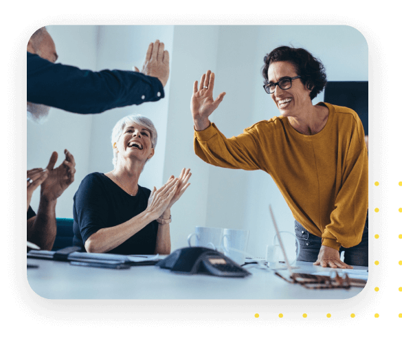 A diverse team celebrating success with a high-five in a modern office setting, showcasing teamwork, collaboration, and a positive workplace culture.