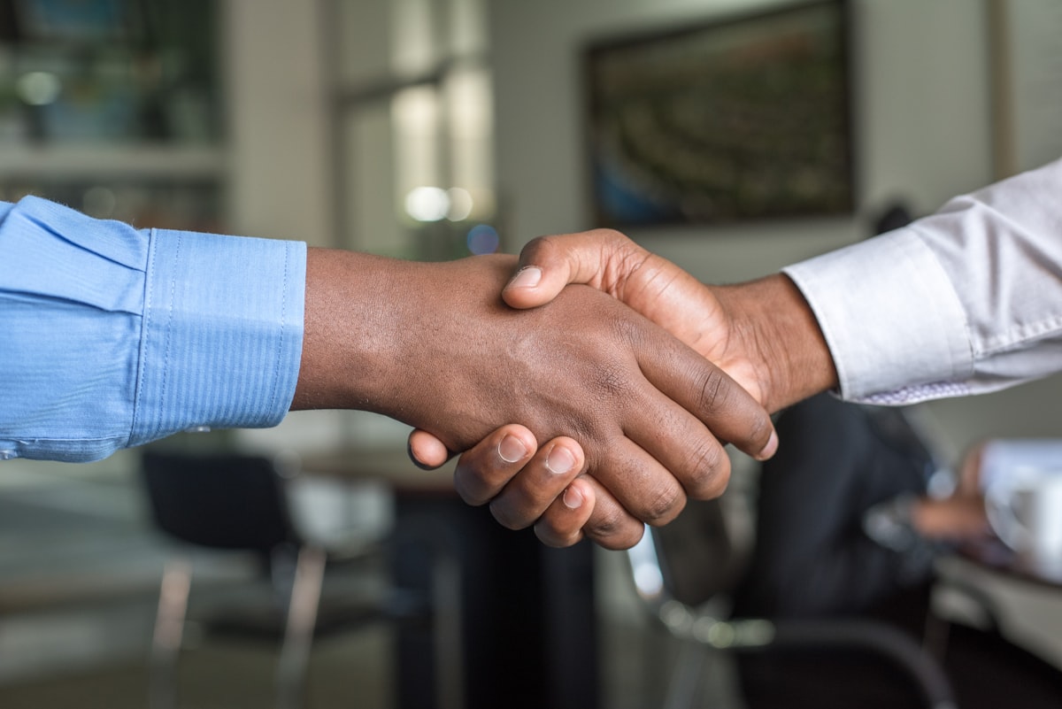 UKG Ready Partner vs Direct: 5 Critical Differences 3 UKG partner vs direct Handshake between two professionals in an office setting symbolizing partnership and collaboration for UKG Ready implementation.